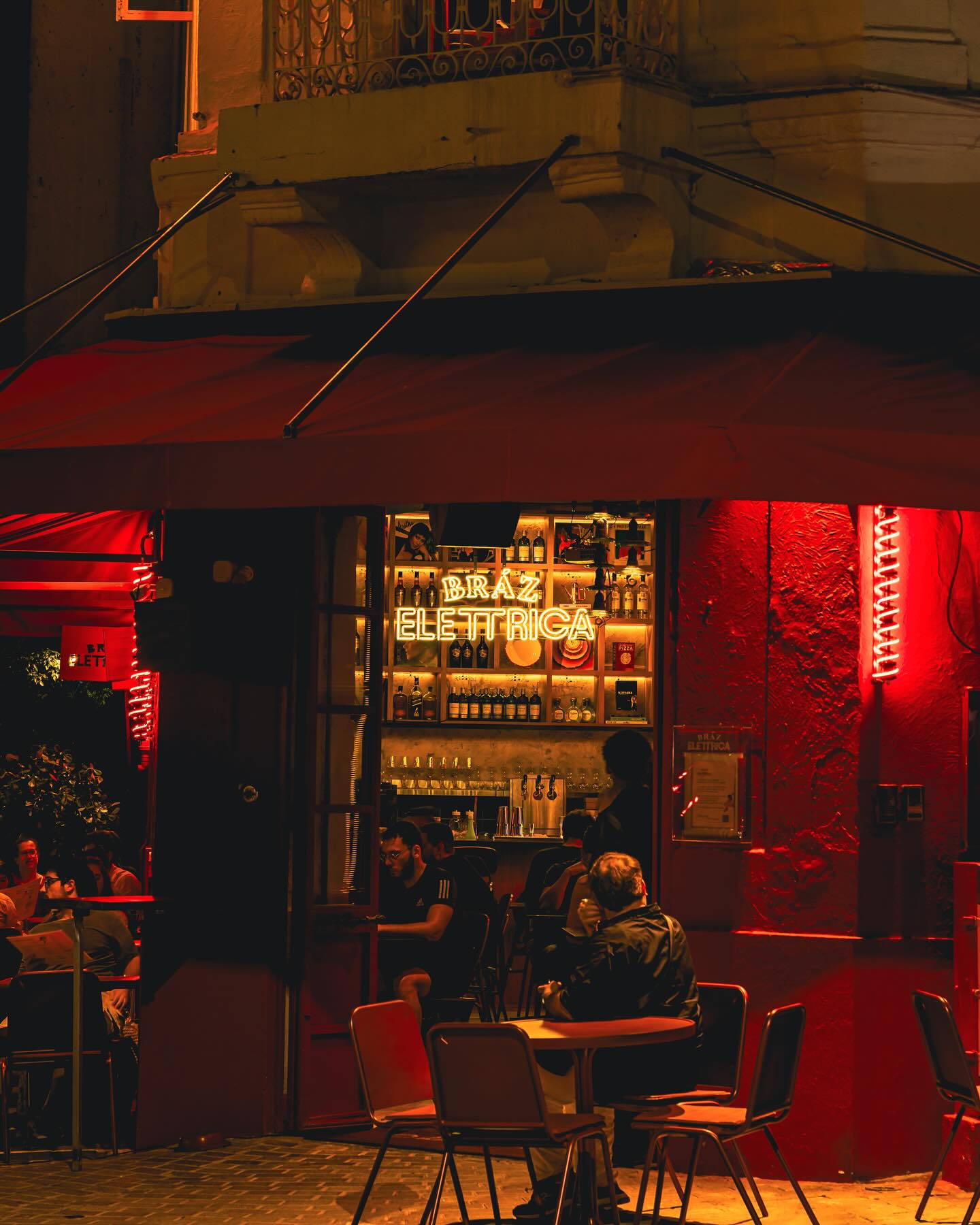 Night terrace with the Bráz Elettrica neon in the window
