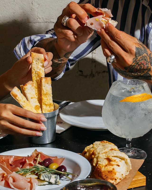 Hands sharing antipasti at the table