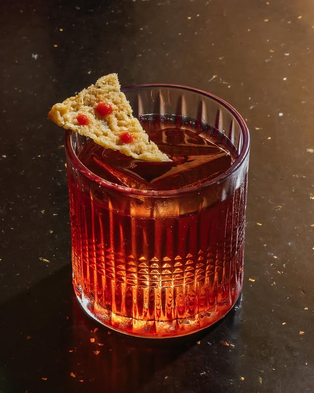 Negroni garnished with a pizza-slice crisp